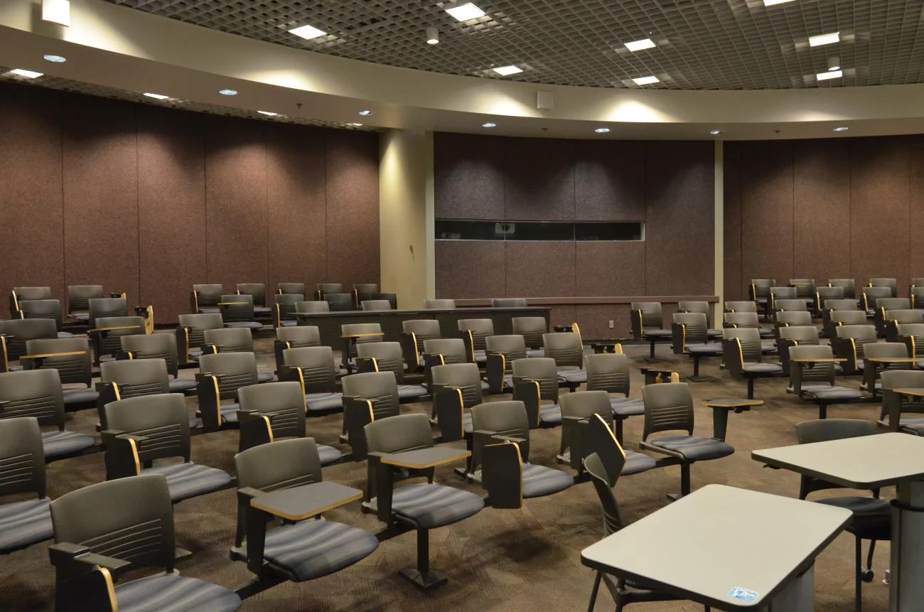 Classroom view, of rows of desks from the front of the room.