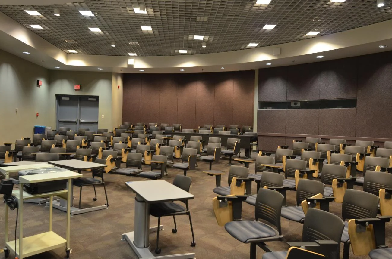 Classroom view, of rows of desks from the front of the room.